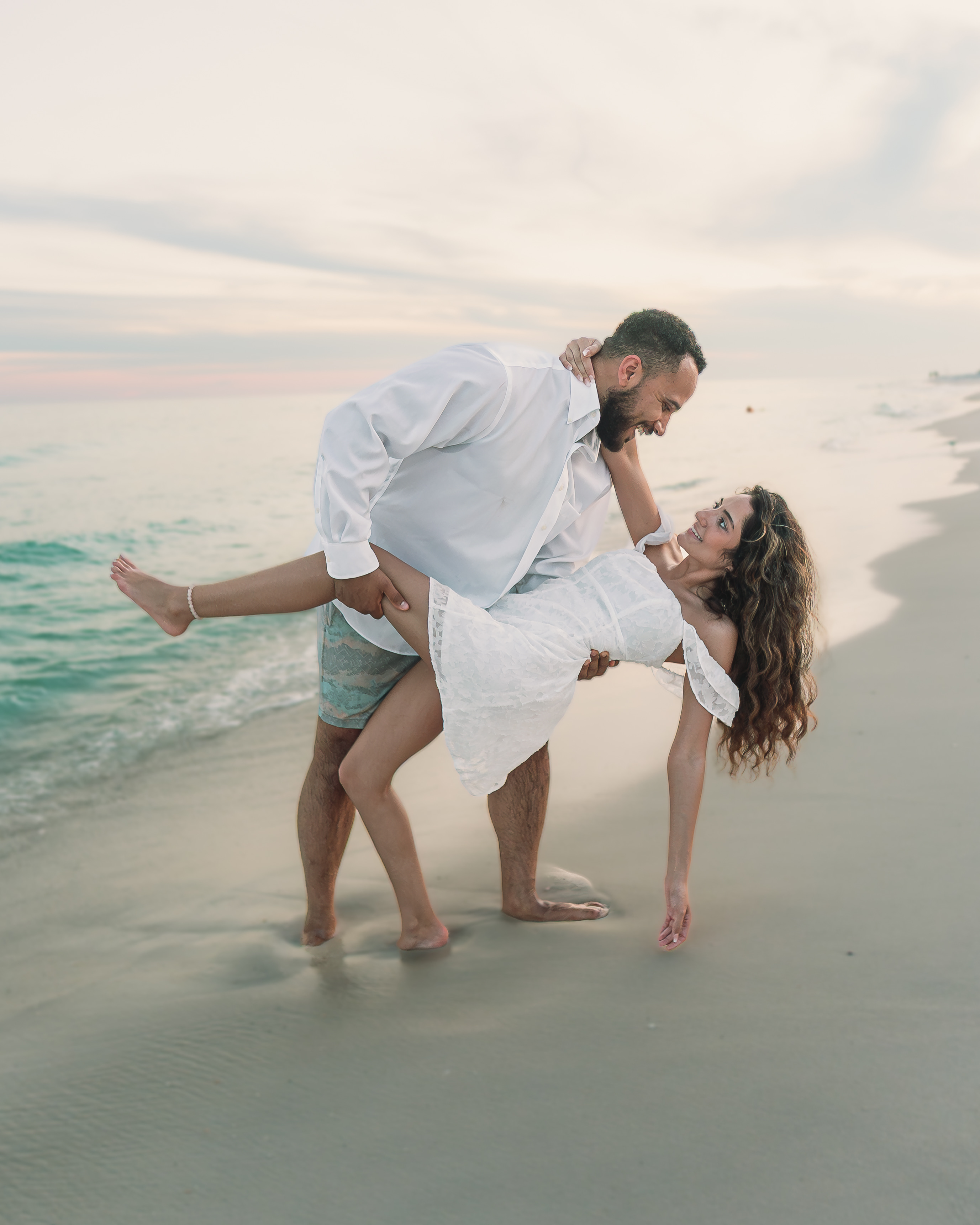 An engaged couple sharing a close moment in warm sunset light