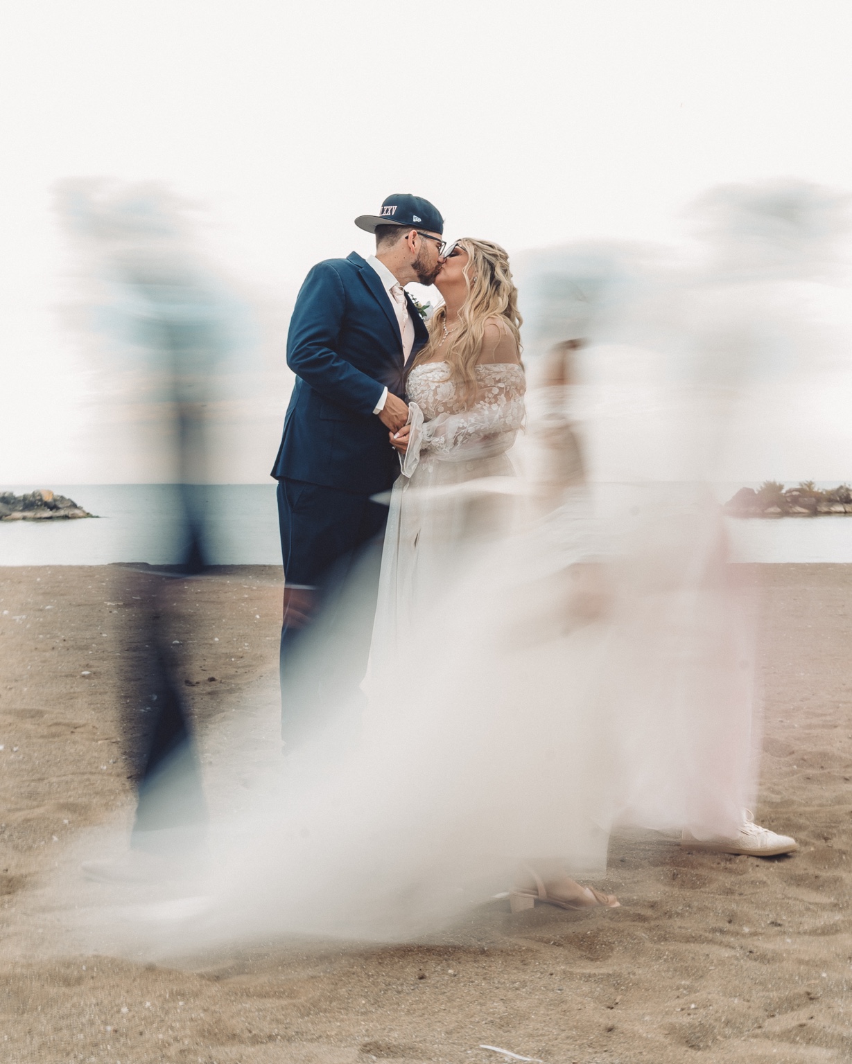 A couple share a soft, motion-filled portrait beneath a flowing veil